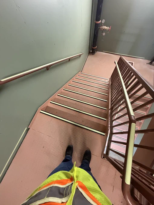 Photo of glow-in-the-dark obstruction markings and stair and handrail nosings on installation day at The Rambler Tempe student apartments in Tempe, Arizona. Stairwell glow markings installed by Luminous Egress for Layton Construction.
