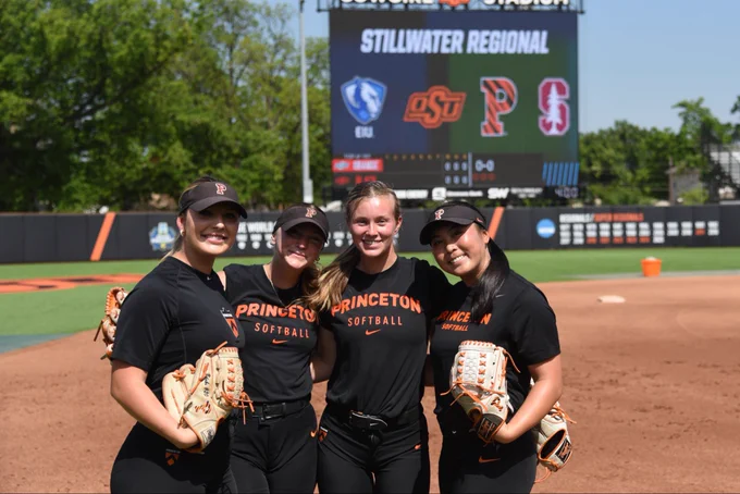 Pitchers pose for a photo in front of the scoreboard