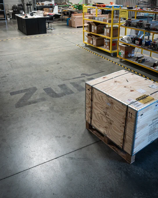 Shipping crate at Zuri's Prague aerospace workshop, with the Zuri logo on the floor.