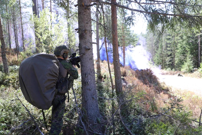 taisteluvarustuksessa oleva varusmies metsässä