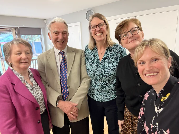 a group picture of four women and one man smiling at the camera.