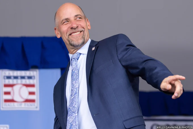 John Smoltz takes the stage wearing a navy suit and paisley tie during the 2024 Induction Ceremony. (Kelly Gavin/MLB Photos)