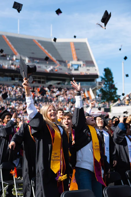 Graduates throw their caps in the air during commencement.