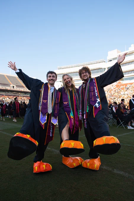 Three grads pose in HokieBird feet.