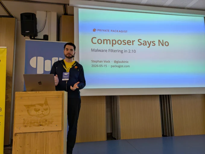 Stephan Vock in front of a slide saying "Composer Says No" subtitle "Malware Filtering in 2.10"