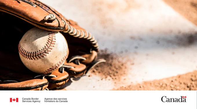baseball glove and ball on dirt.