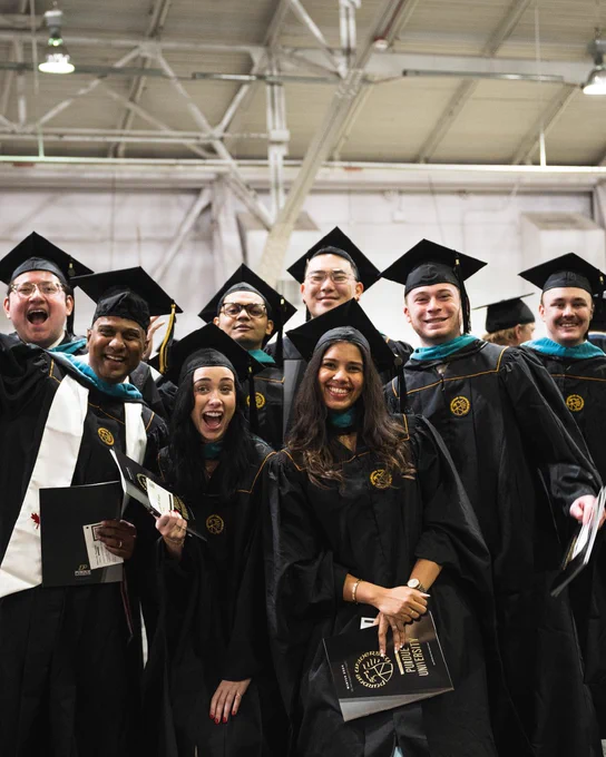 Group of graduating seniors in black Boilermaker cap and gowns
