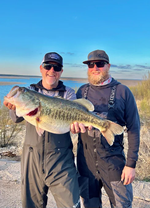 Fishing guide poses with man holding big largemouth bass