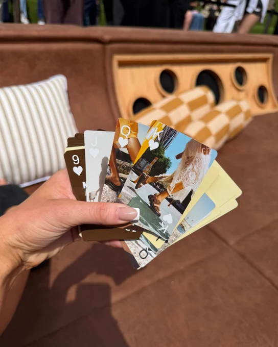 An image of a person's hand holding multiple photos of people wearing Dr Martens sandals.