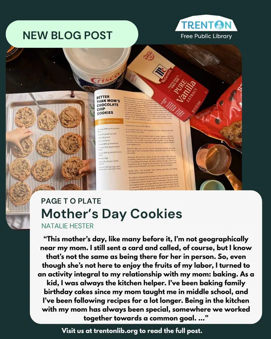 Overhead view of a baking scene with a tray of freshly baked cookies, a recipe book open to a chocolate chip cookie recipe, vanilla extract, and baking ingredients on a kitchen counter.