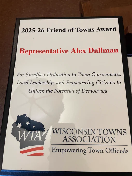 Close-up of the framed 2025-26 Friend of Towns Award plaque presented to Representative Alex Dallman by the Wisconsin Towns Association. The plaque text reads: 'For Steadfast Dedication to Town Government, Local Leadership, and Empowering Citizens to Unlock the Potential of Democracy.' It includes the WTA logo with a stylized Wisconsin map and the tagline 'Empowering Town Officials.