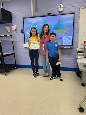 two students posing with ESL teacher Gale Hager to celebrate achievement on state assessment.
