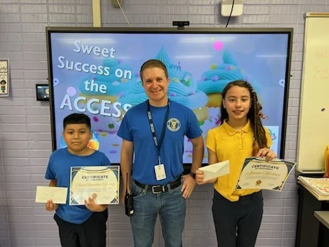 two students posing with Principal Jameson Branch to celebrate achievement on state assessment
