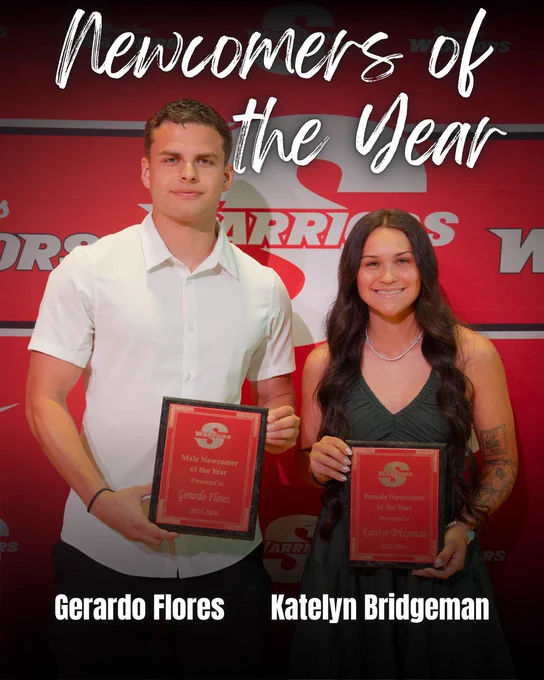 Gerardo Flores and Katelyn Bridgeman pose with their Newcomer of the Year awards at the STANYS. Both stand in front of a red Stanislaus State Athletics backdrop holding plaques recognizing their standout first seasons as Warriors.