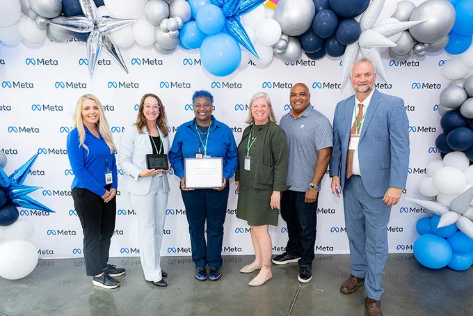 META Employees pose with Rachel Evans, Bonnie Garrett, Elizabeth Fleming, and AJ Buckner to present the Grant Certificate