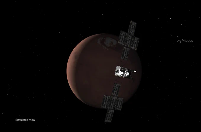 Simulated view of the Psyche spacecraft, with its "wings" of solar panel arrays, approaching the planet Mars, seen in crescent phase.