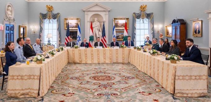 A photo of officials sitting at a conference table.