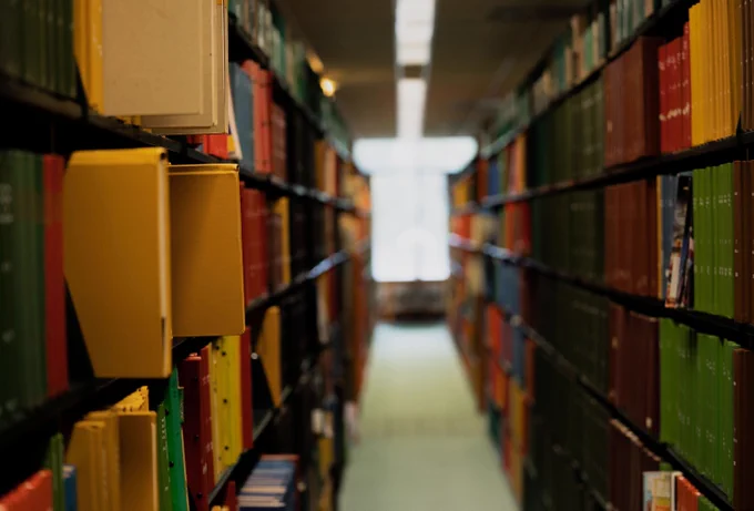Photo between library shelves of colorful books