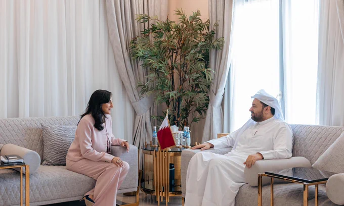 Minister Anand and His Excellency Dr. Mohammed bin Abdulaziz Al-Khulaifi seated across from each other, with a Qatari flag on the table between them.