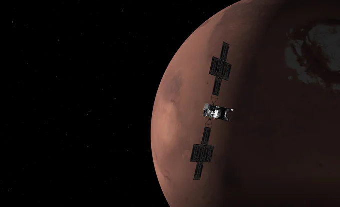 Simulated view of the Psyche spacecraft, with its "wings" of solar panel arrays, growing ever closer to the planet Mars, now seen in nearly half-full phase.