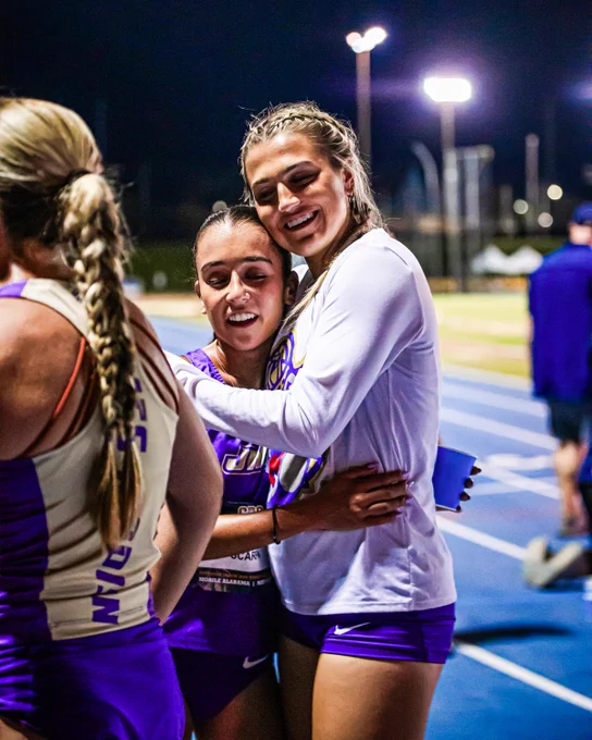 Elizabeth Scarpa receiving a hug on the track from Peyton Mermon following Scarpa's completion of the 10,000-meter race.