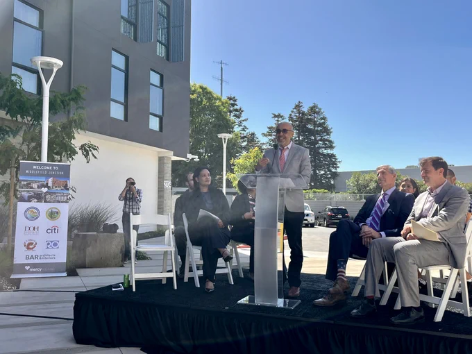 HCD Director Gustavo Velasquez speaking at a podium