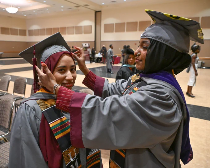 Manhal Amer, Biology major and Samreen Elamahdy adjust her mortar board during the 139th Spring Commencement of the University of Maryland Eastern Shore.