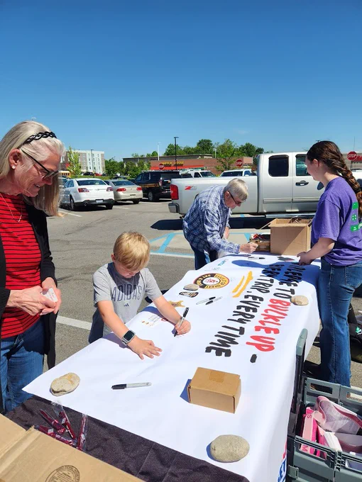 Individuals signing a Click it or ticket poster. 