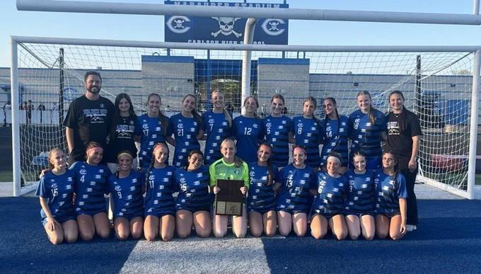 cHS girls varsity soccer team with the downriver league champs plaque