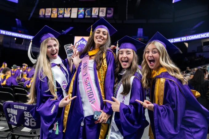 A graduate shows off a pink sash that reads “Happy Birthday”. 