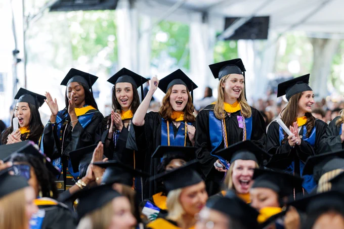 students stand in a crowd at commencement