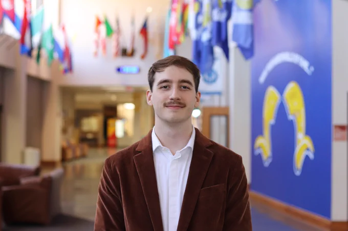 Angelo State University Resident Assistant posing for a graduation photo.