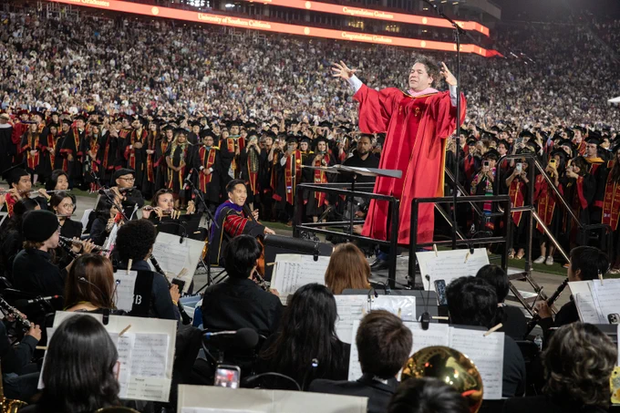 Gustavo Dudamel conducting the Trojan Marching Band at USC's 2026 Commencement with President Kim on cello.