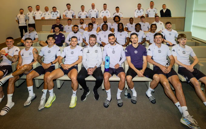 The United players and staff pose for a photo with Bruno Fernandes's Premier League Player of the Season award.