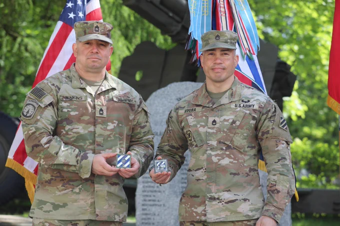U.S. Army Master Sgt. Michael Jenkins and Sgt. 1st Class Matthew Rivera  presents the coins awarded to them during a coin ceremony.