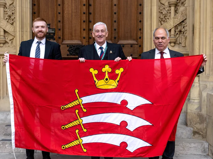 Speaker and two Middlesex MPs posing for a photo with Middlesex flag
