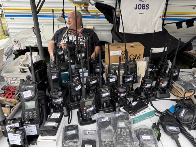 A hamfest flea market booth full of handheld radios.