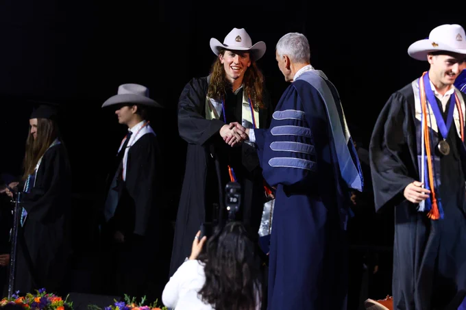 Former Mines soccer player Caden Allaire shakes president Paul Johnson's hand during spring 2026 commencement 