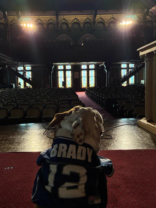 Jack sitting with his back to the camera wearing a Tom Brady jersey 


