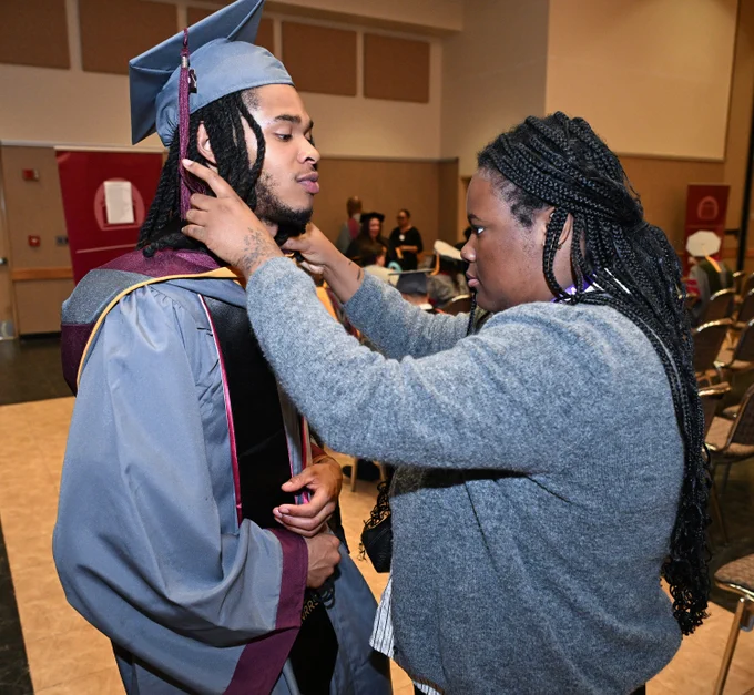 SANS Pre-Vet graduate Tyler Simmons, gets help from UMES Staffer Logan Quinn during the 139th Spring Commencement of the University of Maryland Eastern Shore.