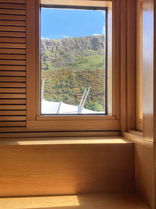 View out of a window of the Scottish Parliament of the crags