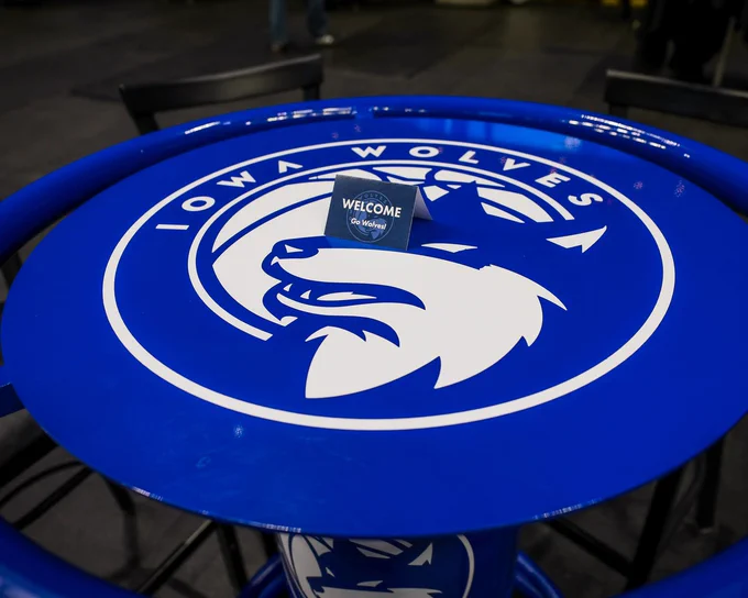 A blue high top table with the Iowa Wolves logo in white at the center. 