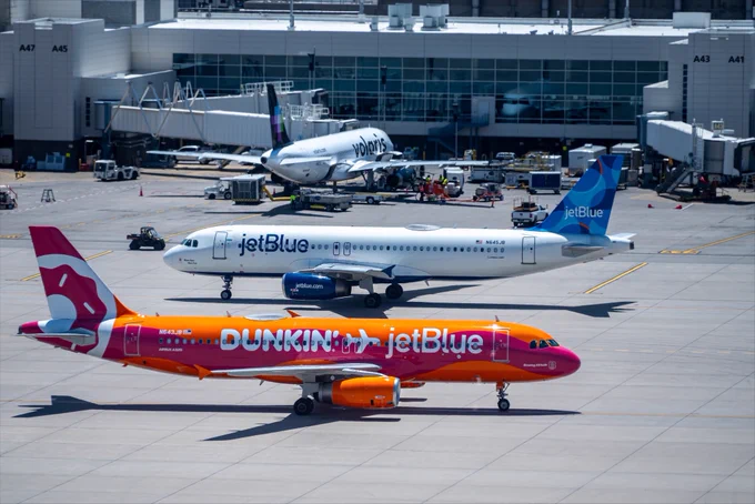 Two JetBlue airplanes taxi past one another at DEN.