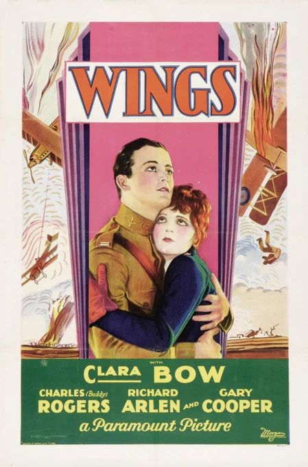 A vintage movie poster for "Wings" from Paramount Pictures. It depicts two people embracing, surrounded by an aerial battle with planes and flames in the background. The names Clara Bow, Charles Rogers, Richard Arlen, and Gary Cooper are prominently displayed.