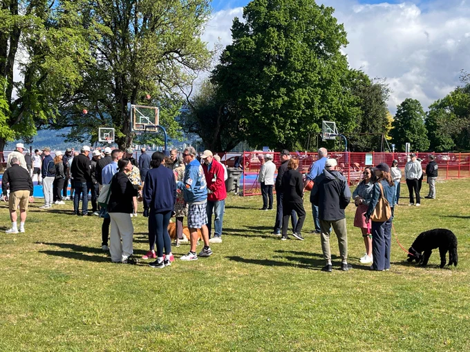 A group of people gathered around a basketball court