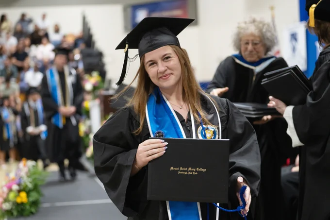Graduate holds diploma case after walking the stage at Commencement.