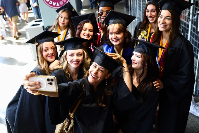 Ten graduates take a selfie together.