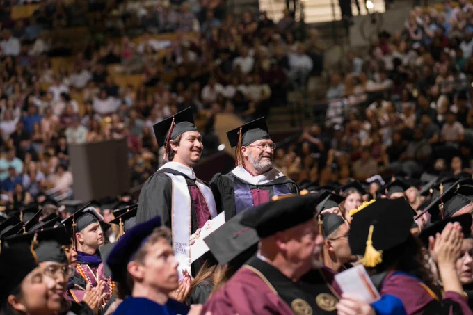 Tyler and Jeff Cannon stand to be recognized as father and son graduate from TXST Master's program together