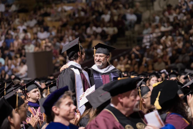 Tyler and Jeff Cannon stand to be recognized as father and son graduate from TXST Master's program together