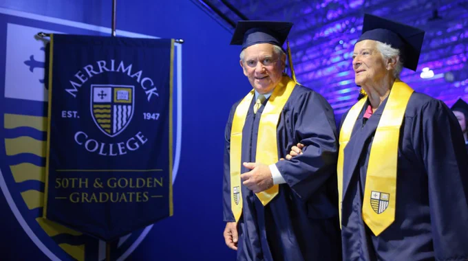 Two Golden Graduates walk out of Lawler Arena after Commencement at Merrimack College.